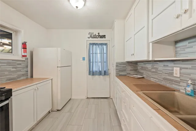 a kitchen with granite countertop a sink stove and refrigerator
