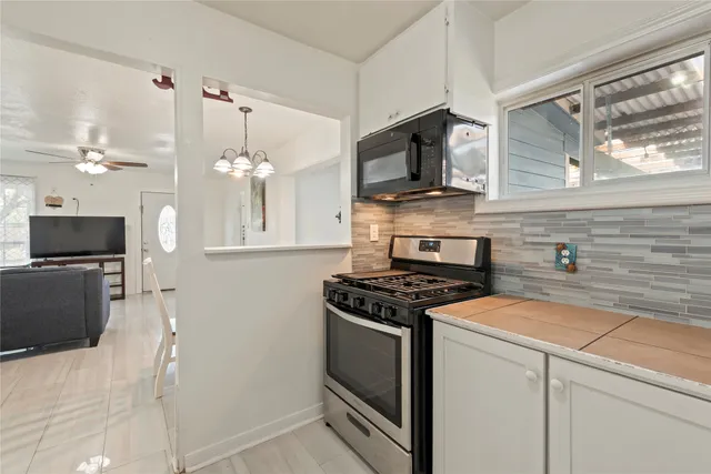 a kitchen with stainless steel appliances granite countertop a stove and a microwave