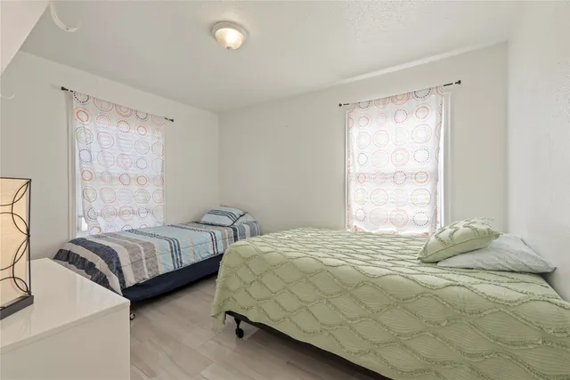 a bedroom with two beds and a large window