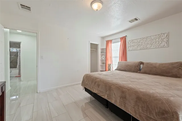 a bedroom with a large bed and a window