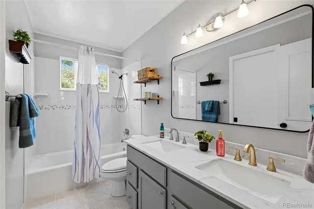 a bathroom with a sink a toilet a mirror and shower