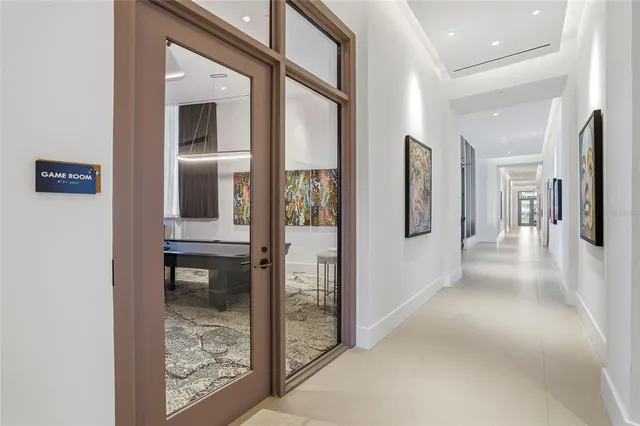 a view of hallway with walk in closet and wooden floor