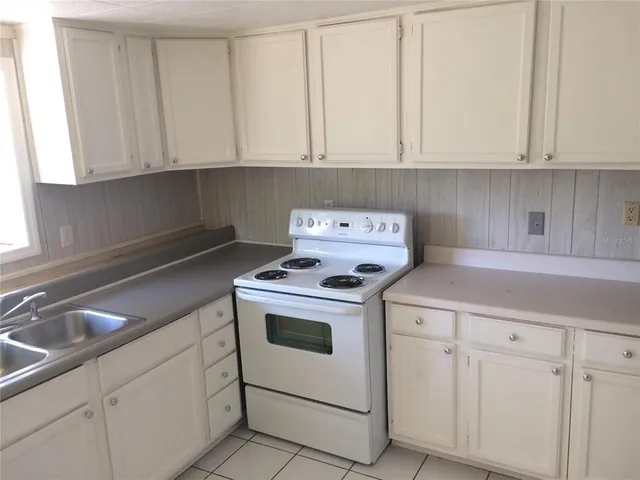 a kitchen with white cabinets and white appliances