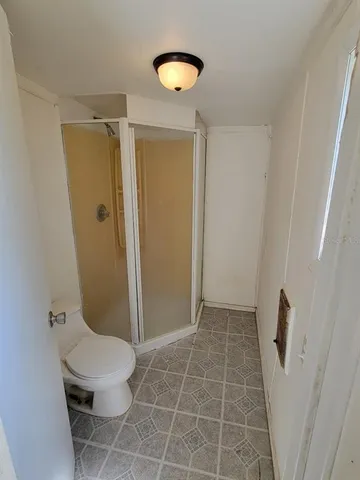 a bathroom with a toilet and a shower