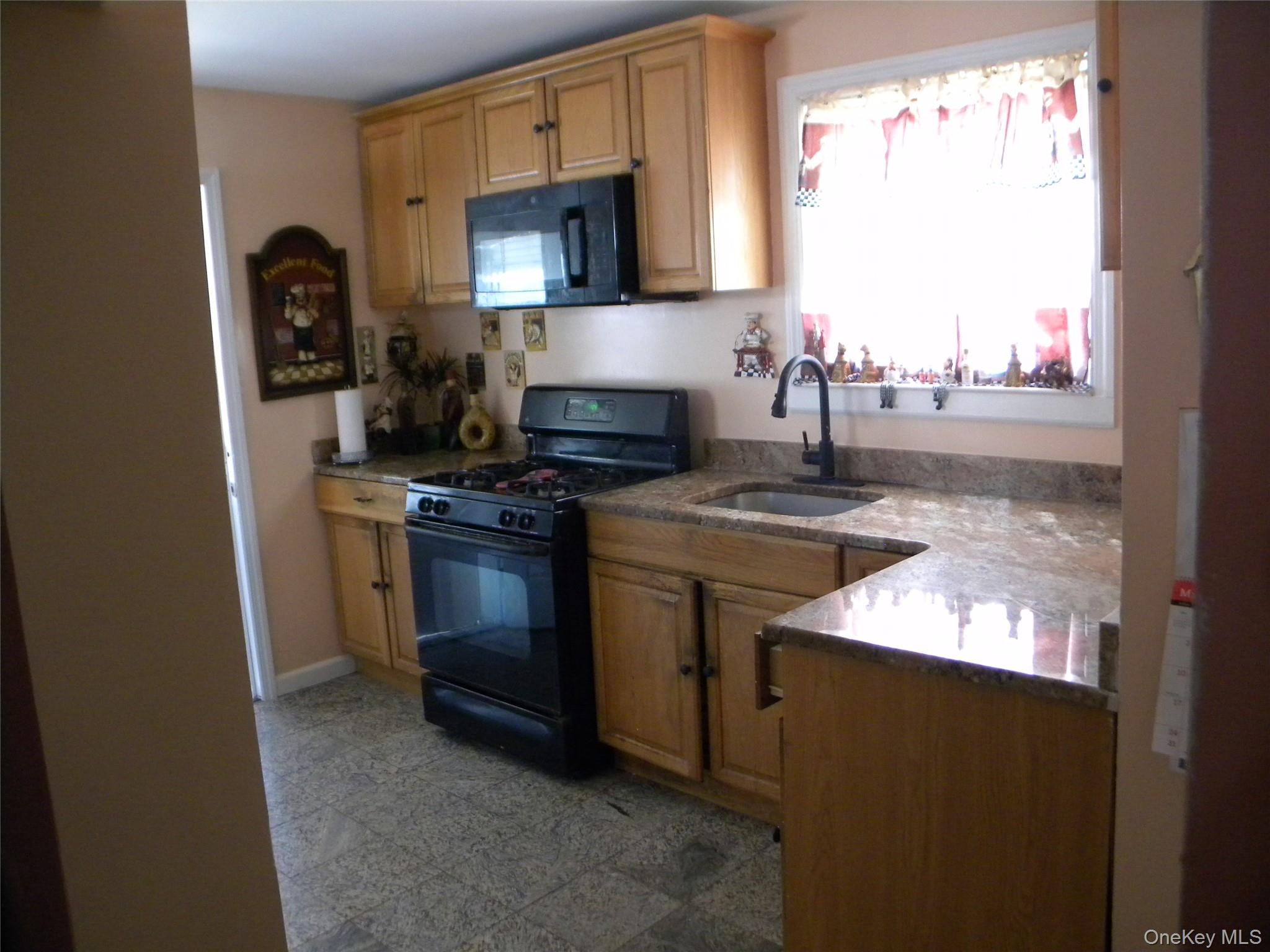 241-26 86th Road Queens, NY 11426 - Photo 10 of 38 a kitchen with stainless steel appliances granite countertop a stove a sink and a microwave