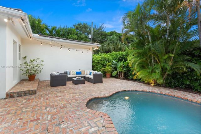 a view of a house with swimming pool and sitting area