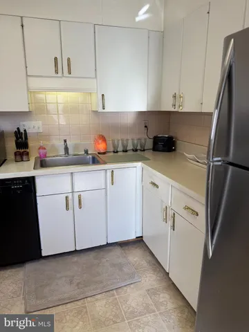 a kitchen with white cabinets stainless steel appliances and sink
