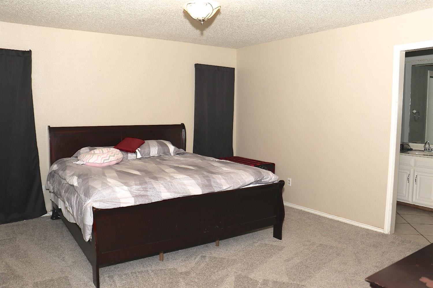 7004 Elkhart Avenue Lubbock, TX 79424 - Photo 5 of 44 a bed sitting in a bedroom next to a window with a tv