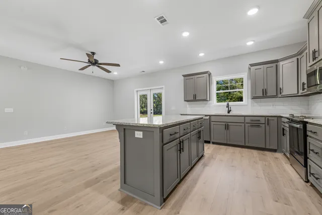 an empty room with a window and a fan