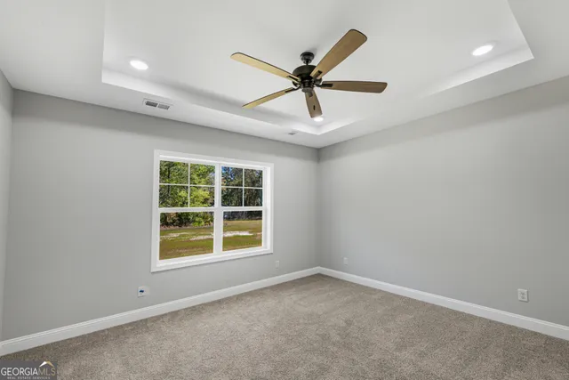 an empty room with chandelier fan