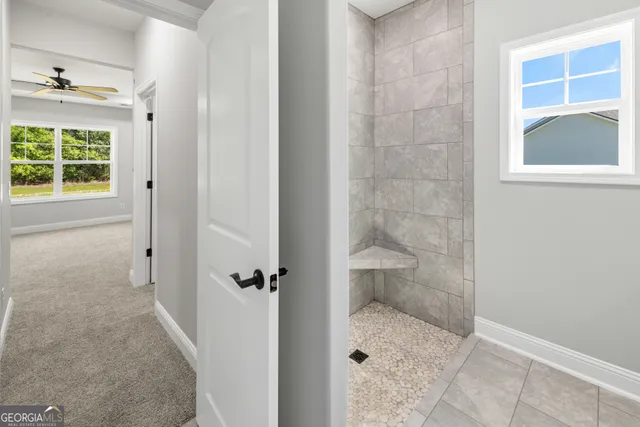 an empty room with a window and a fan