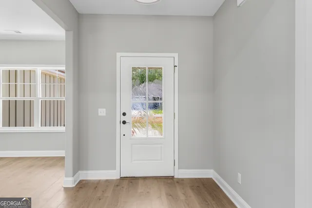 an empty room with a window and ceiling fan