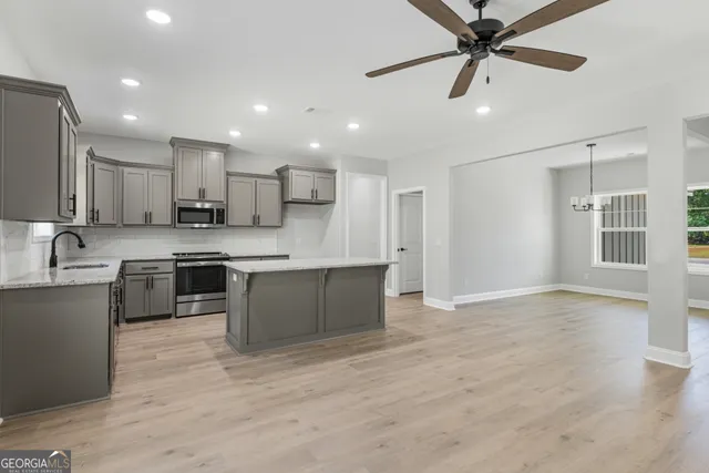 a kitchen with stainless steel appliances granite countertop a sink a stove and a refrigerator