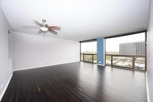 4343 North Clarendon Avenue, Unit 1113 Chicago, IL 60613 - Photo 2 of 7 a view of an empty room with wooden floor and a window