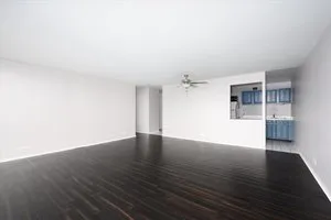 a view of a big room with wooden floor and a kitchen
