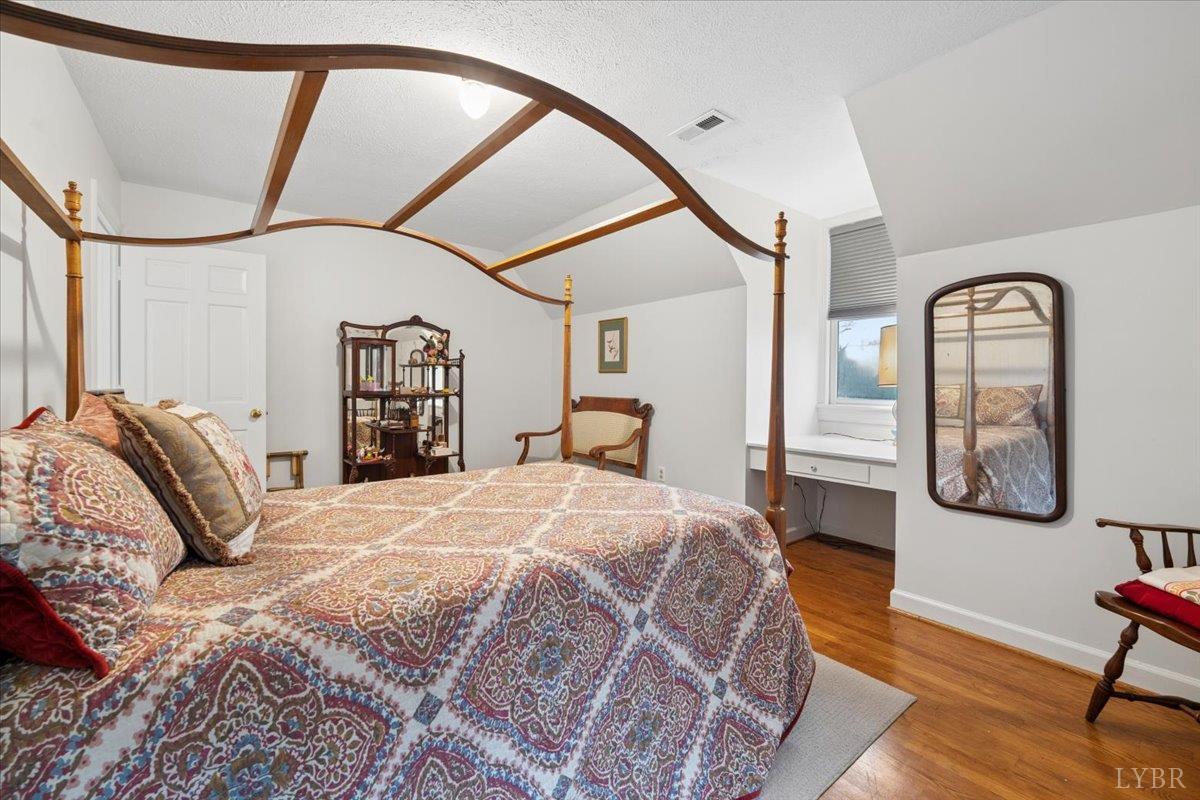 3289 Peaks Road Bedford, VA 24523 - Photo 61 of 71 a spacious bedroom with a bed a mirror on dresser and a windows