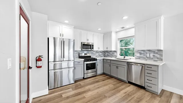 a kitchen with stainless steel appliances a refrigerator sink and microwave