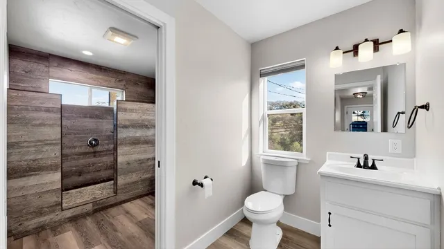 a bathroom with a toilet sink shower and mirror