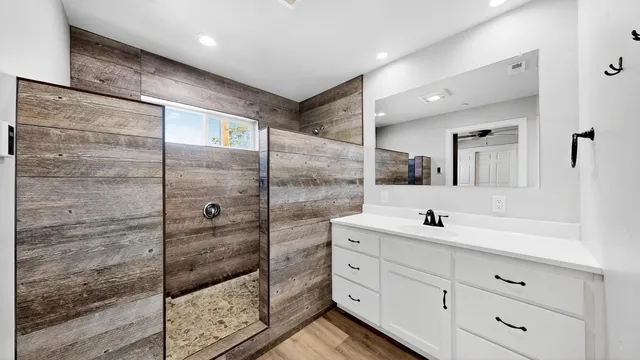 a bathroom with a shower sink and mirror