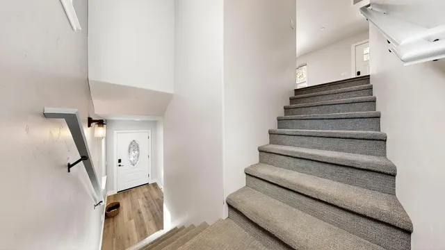 a view of a hallway with wooden floor and entryway