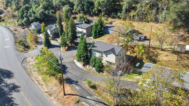 an aerial view of a house with a yard and a large tree
