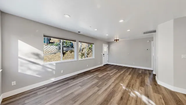 wooden floor in an empty room with a window