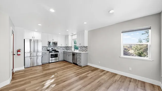 a kitchen with refrigerator cabinets and wooden floor