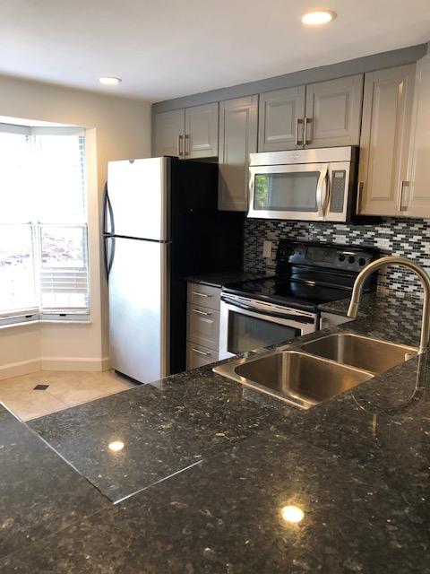 1072 Jeffery Street Boca Raton, FL 33487 - Photo 1 of 38 a kitchen with kitchen island a counter top space cabinets and stainless steel appliances