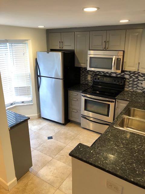 1072 Jeffery Street Boca Raton, FL 33487 - Photo 13 of 38 a kitchen with granite countertop a refrigerator and a stove top oven