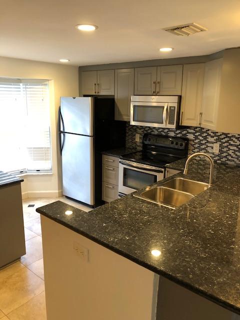 1072 Jeffery Street Boca Raton, FL 33487 - Photo 15 of 38 a kitchen with granite countertop a refrigerator a stove and a sink