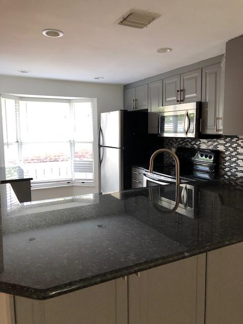1072 Jeffery Street Boca Raton, FL 33487 - Photo 16 of 38 a kitchen with a sink a stove and a refrigerator