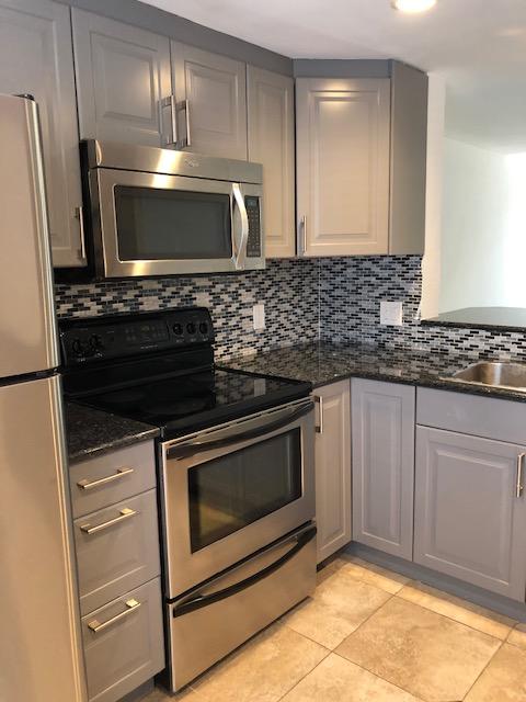 1072 Jeffery Street Boca Raton, FL 33487 - Photo 3 of 38 a kitchen with granite countertop a stove microwave and sink