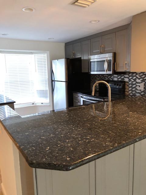 1072 Jeffery Street Boca Raton, FL 33487 - Photo 10 of 38 a kitchen with kitchen island a sink stainless steel appliances and counter space