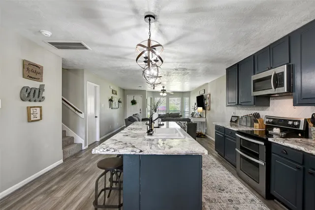 a kitchen with stainless steel appliances granite countertop a sink stove and refrigerator