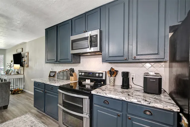 a kitchen with stainless steel appliances granite countertop a sink stove and microwave