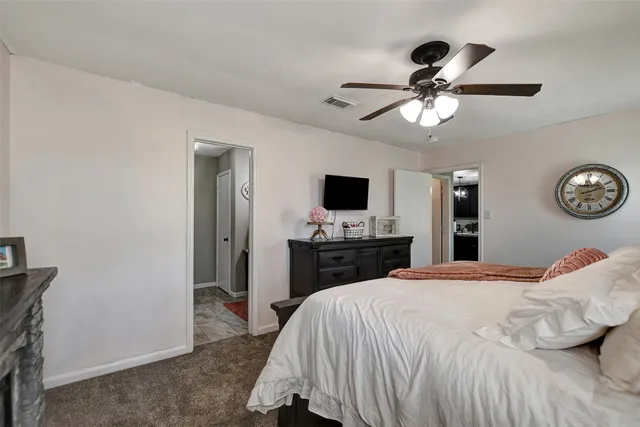 a bedroom with a bed and a flat tv screen on dresser