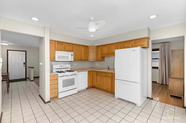 a kitchen with a refrigerator a stove top oven and cabinets