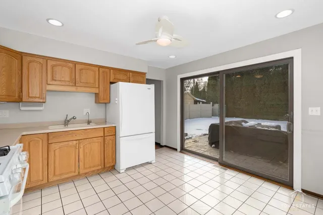 a kitchen with white cabinets and refrigerator