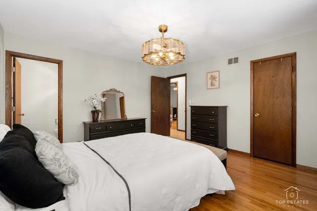 a bedroom with a large bed and a chandelier