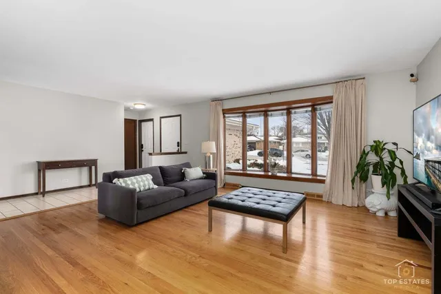 a living room with furniture and a large window with wooden floor
