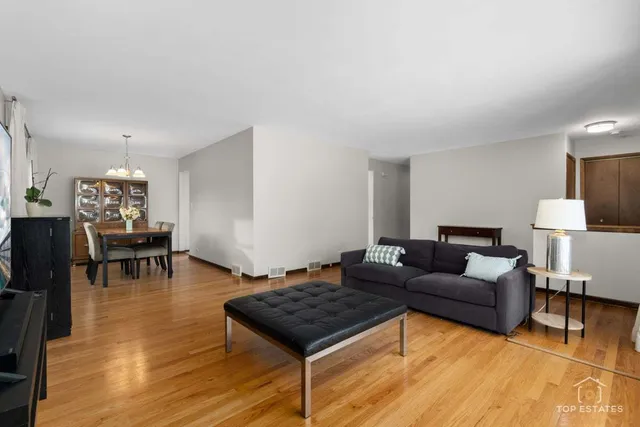 a living room with furniture and a dining table with wooden floor