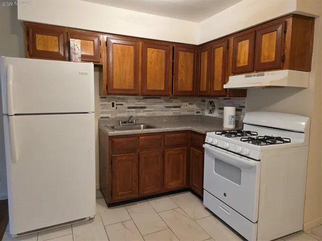 a kitchen with a stove top oven and cabinets