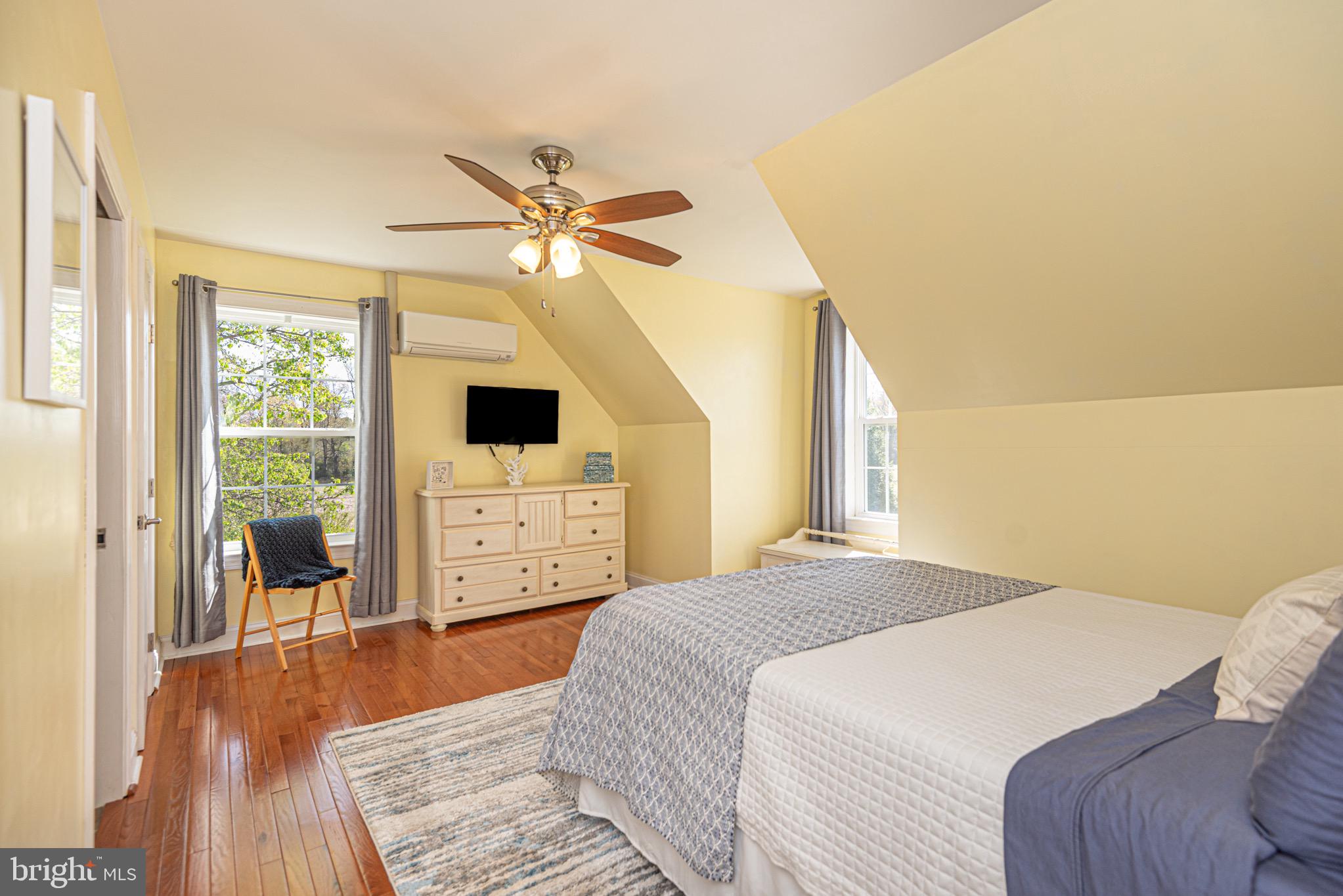 12740 Jarvis Road Bishopville, MD 21813 - Photo 36 of 47 a bedroom with a bed a flat tv screen and a large window with wooden floor