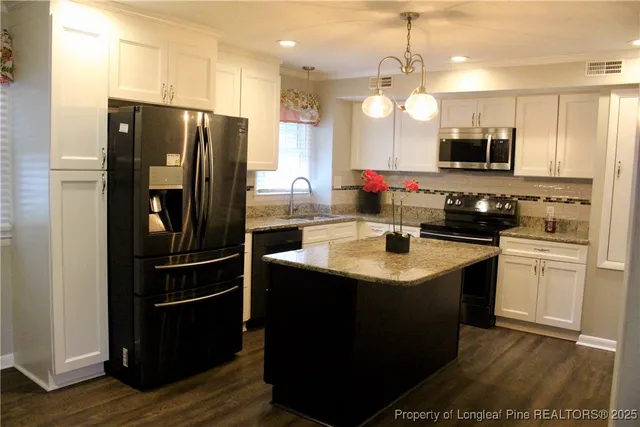 a kitchen with granite countertop a stove and a microwave