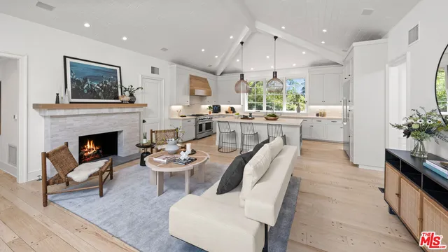 a dining room with furniture a large window and a fireplace