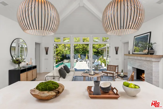 a living room with furniture a fireplace and a chandelier