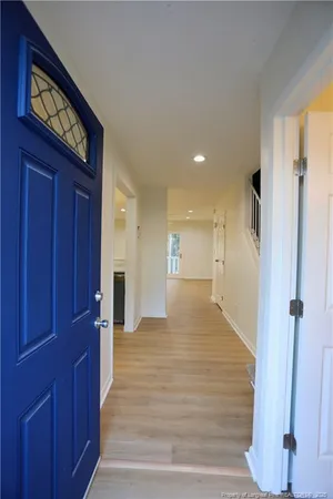 a view of a hallway with wooden floor and staircase