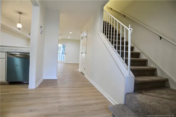 a view of entryway and hall with wooden floor