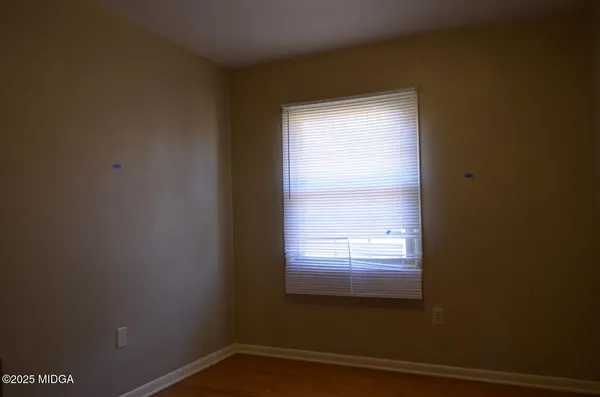 a view of a small space with wooden floor and a window