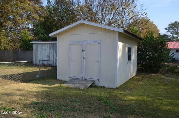 a view of a backyard with a cabin and wooden fence